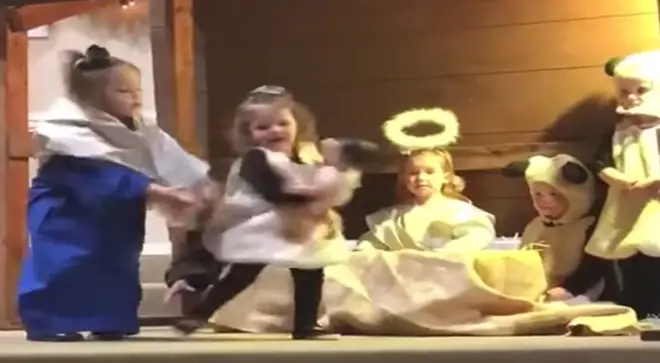 Mary tries to take the baby doll back from the sheep in the nativity play