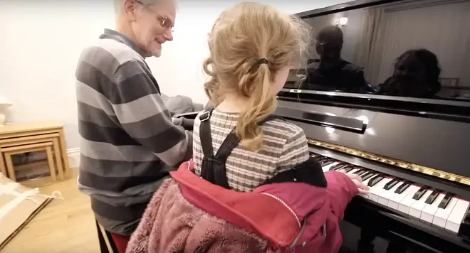 The little girl joins her grandad at the piano for a duet in the festive advert