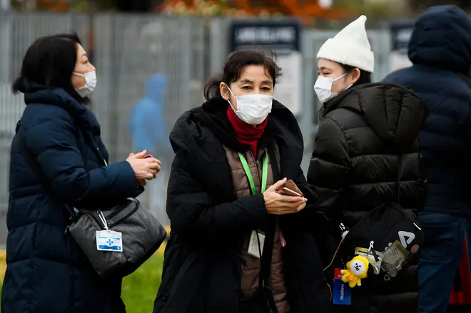 Passengers wearing respiratory masks exit the port of Civitavecchia, north of Rome, early on January 31, 2020
