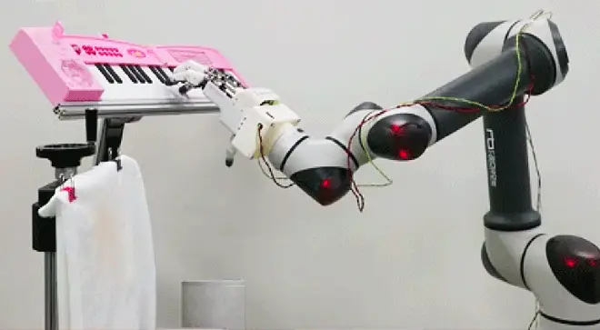 Robotic hand plays notes on a keyboard