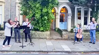 Cardiff-based musicians perform social distancing concert on the street.