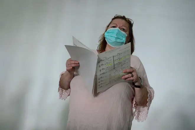 A singer of the Apostol Santiago choir wearing a face mask attends their first rehearsal