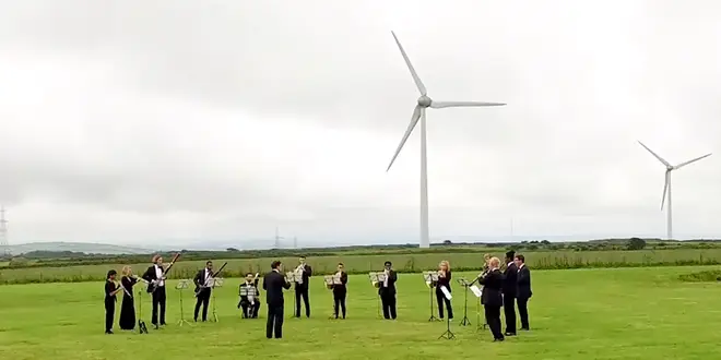 Orchestra for the Earth perform under wind turbines to mark this year's Earth Overshoot Day