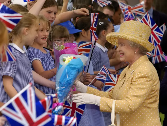 The Queen is given flowers from schoolgirls during her Golden Jubilee visit to West London