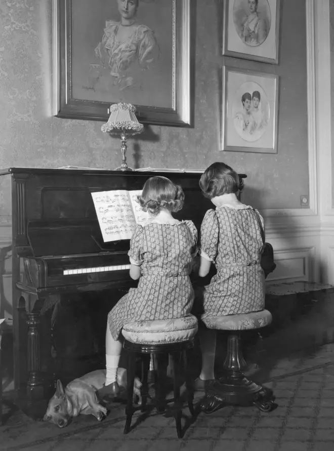 Princess Elizabeth and Princess Margaret seated together at the piano at Windsor Castle, 1940.