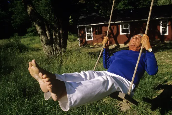 Composer Leonard Bernstein swings outside of his Fairfield, Connecticut home (1986)