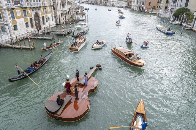 Violin-shaped boat parades near the Accademia Bridge in Venice, Italy.
