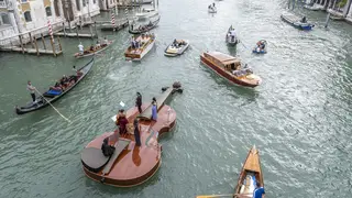 Violin-shaped boat parades near the Accademia Bridge in Venice, Italy.
