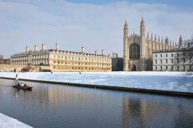 Punting along river Cam in winter snow with Kings College Chapel to the rear Cambridge, England