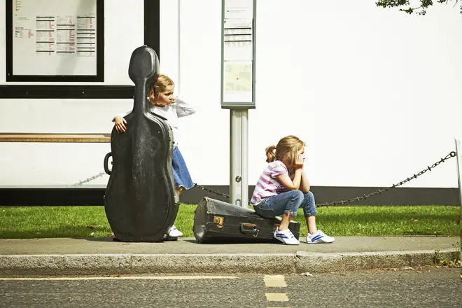 Two young musicians waiting for the bus