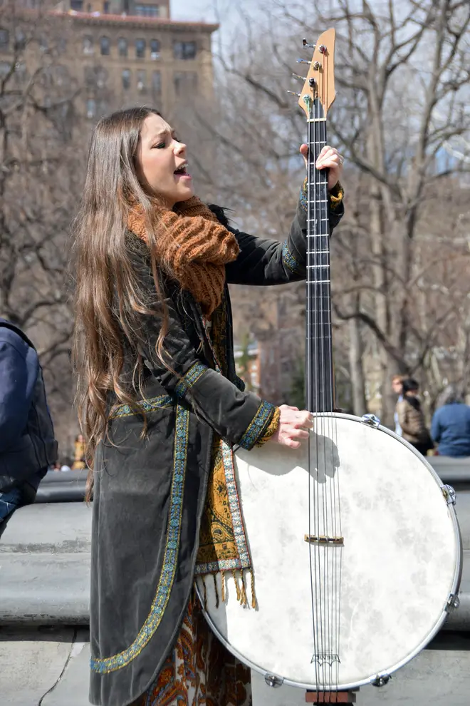 A young musician plays a homemade electric bass in Washington Square Park in New York City