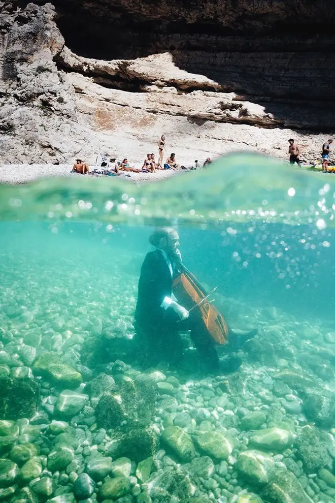 Møldrup took the cello underwater as holiday goers watched from the beach