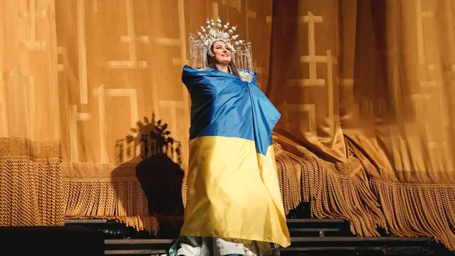 Ukrainian soprano Liudmyla Monastyrska taking a curtain call draped in her country’s flag