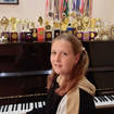 Darynka at the piano with her many awards