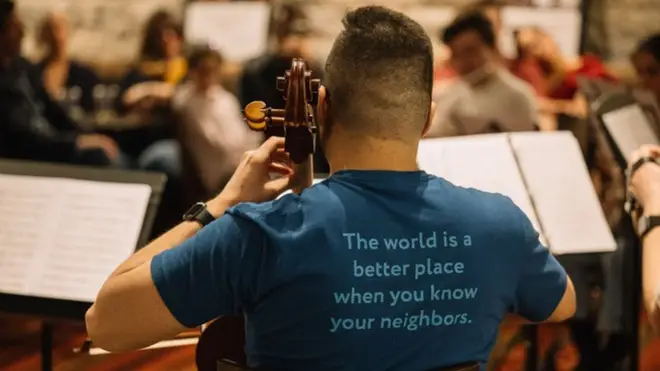 CAYO message in action on the back of cellist Omar Macias, May 2022 Residency