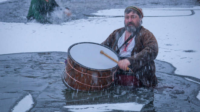 Drummer breaks the ice of the river in Bulgaria during traditional Epiphany Day celebrations