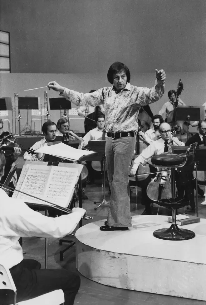 Conductor André Previn leading an orchestra in 1974