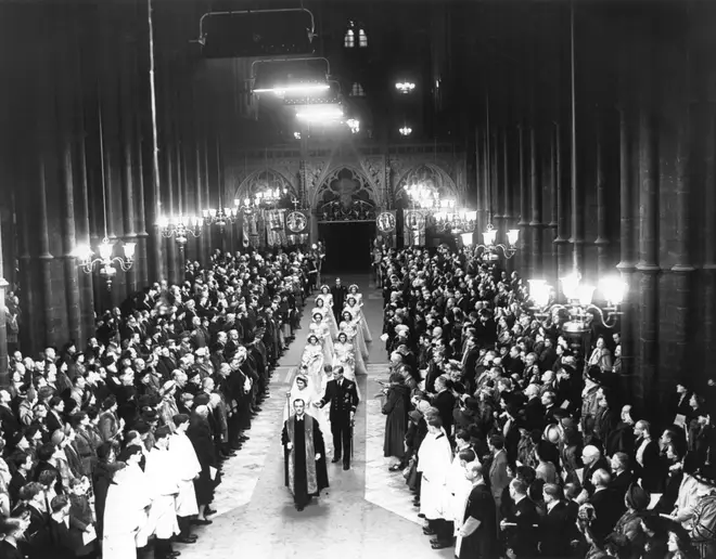 Queen Elizabeth II, as Princess Elizabeth, walks up the aisle of Westminster Abbey, London, with her father King George VI, to marry the Duke of Edinburgh,