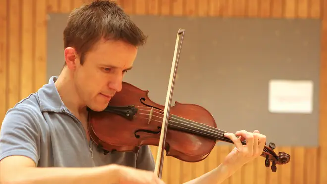 Adrian playing the violin as an adult