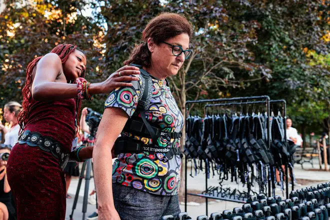 A user gets a haptic suit fitted to their body ahead of an orchestral concert at the Lincoln Center.