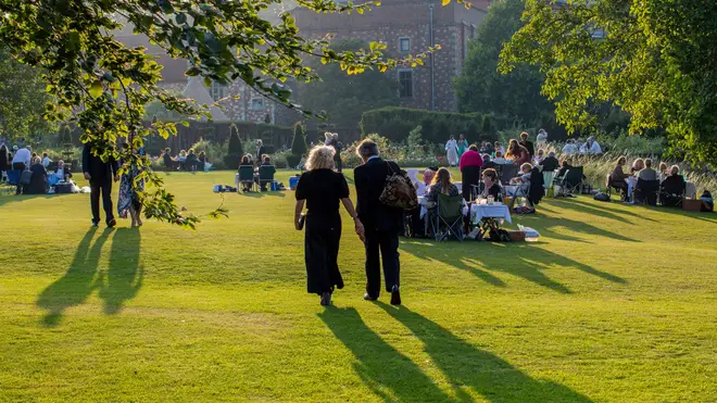 A couple walk back towards Glyndebourne Manor House during the Interval of Mozart’s The Magic Flute