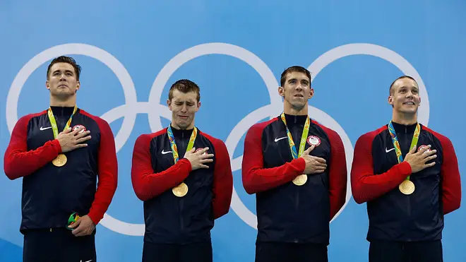 Members of the US swimming team emotionally receive their gold medals while their national anthem plays at the Rio 2016 Olympics.