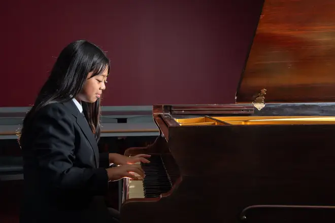A pupil playing piano at the academy
