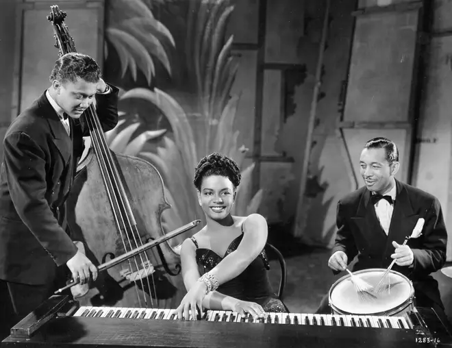 Hazel Scott playing keyboard alongside a double bassist and percussionist, circa 1945.