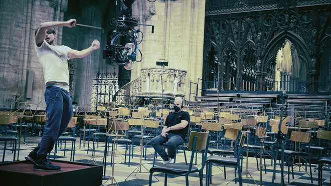 Bradley Cooper rehearses on the conductor’s podium in Ely Cathedral, coached by Yannick Nézet-Séguin (seated).