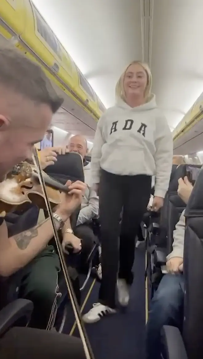 A passenger joins in the fiddler's performance, performing a Riverdance in the aisle