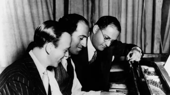 George Gershwin (centre) at the piano with his brother, Ira (right) and Fred Astaire (left)